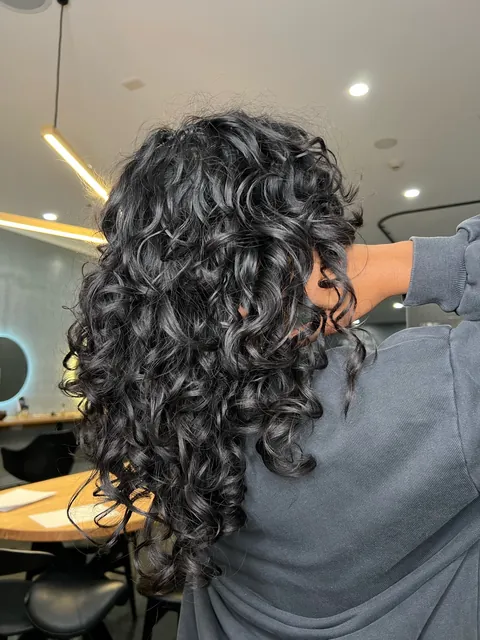 Long, defined natural curls after a curly cut