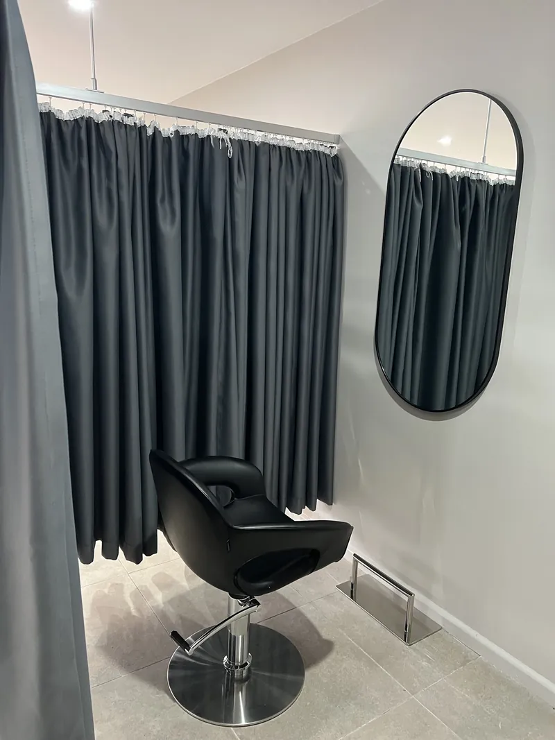 Private styling room behind a charcoal curtain, with an arched mirror
