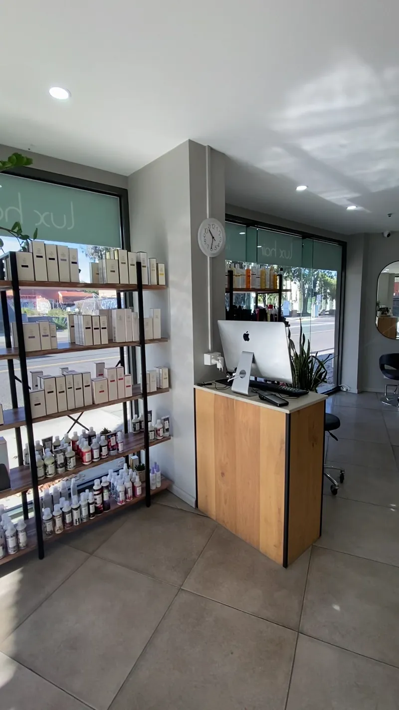 Retail shelves of hair products beside the timber reception desk